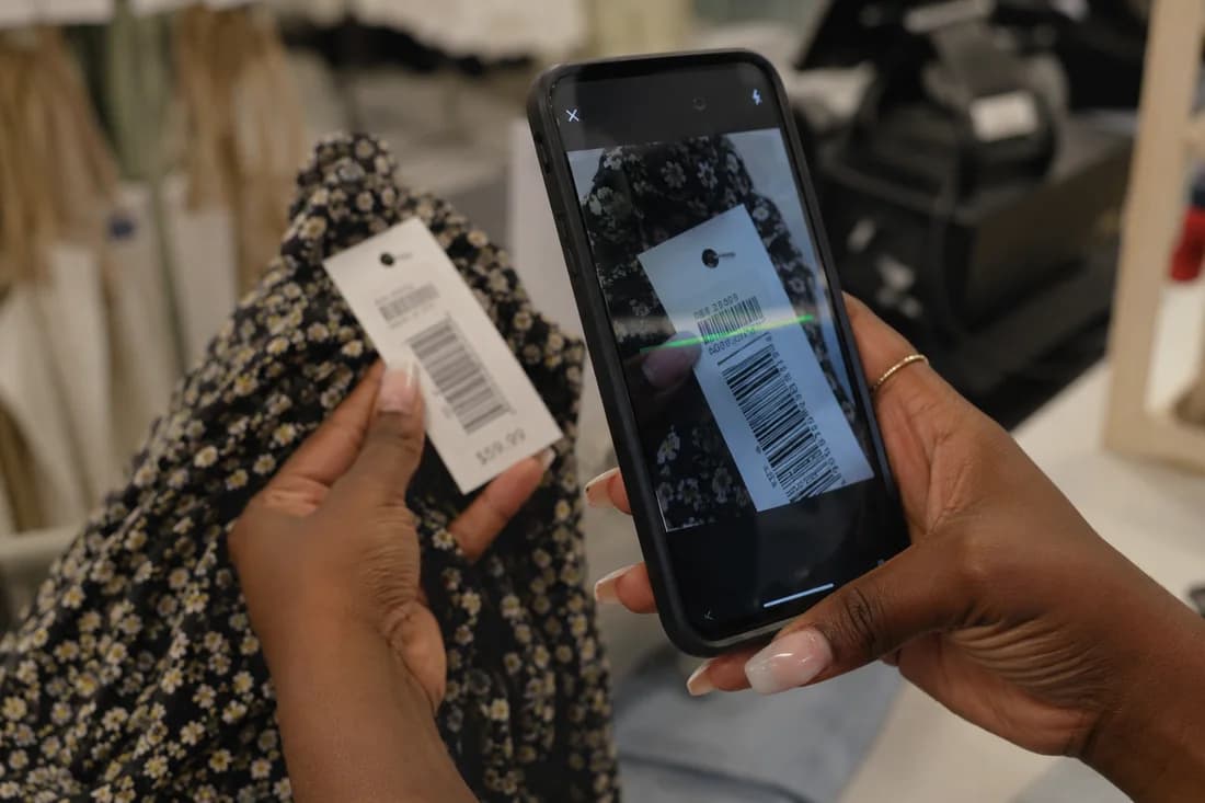 Lojista bipando o código de barras de um produto com a câmera do celular no Stoqui